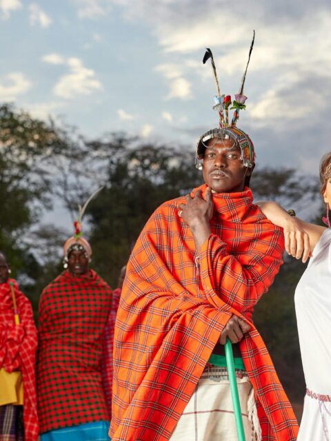 A group showcasing traditional Maasai attire against a vibrant Kenyan landscape.