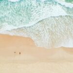 Serene aerial view of Castaways Beach in Queensland with gentle waves and sandy shores.