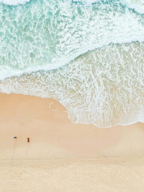 Serene aerial view of Castaways Beach in Queensland with gentle waves and sandy shores.